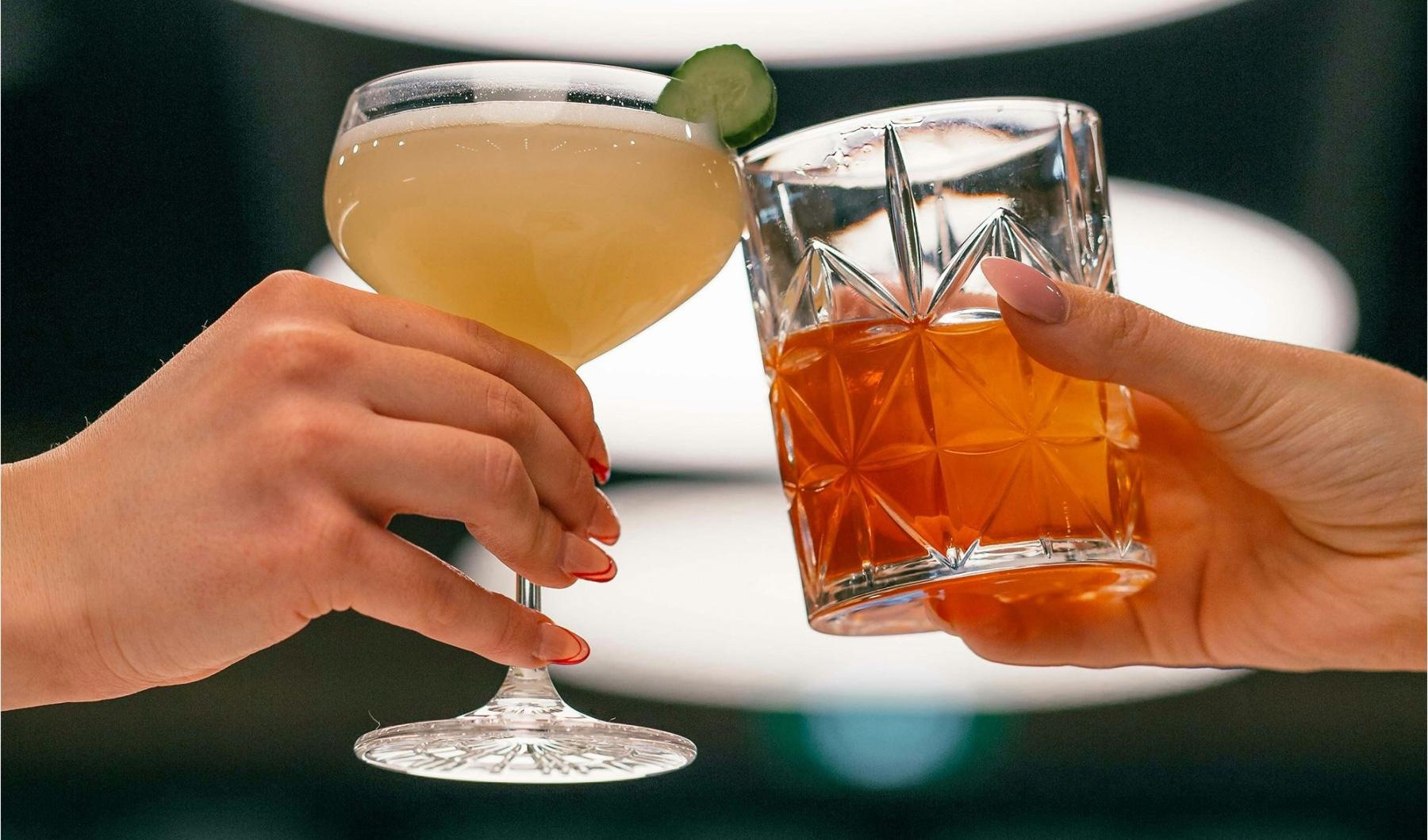 hands holding glasses with cocktails