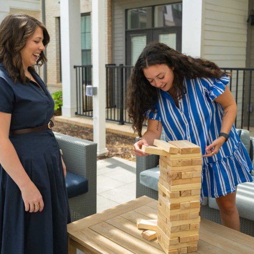 residents playing Jenga on outdoor patio